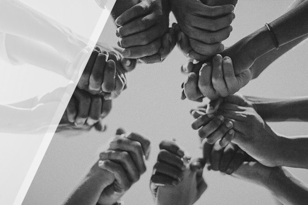 A photo of hands linked together in a circle