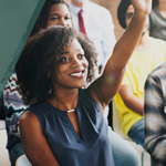 Student smiling and raising her hand.