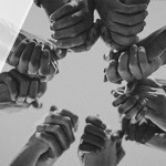 A photo of hands linked together in a circle