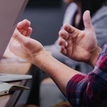 a man's hands raised over a desk
